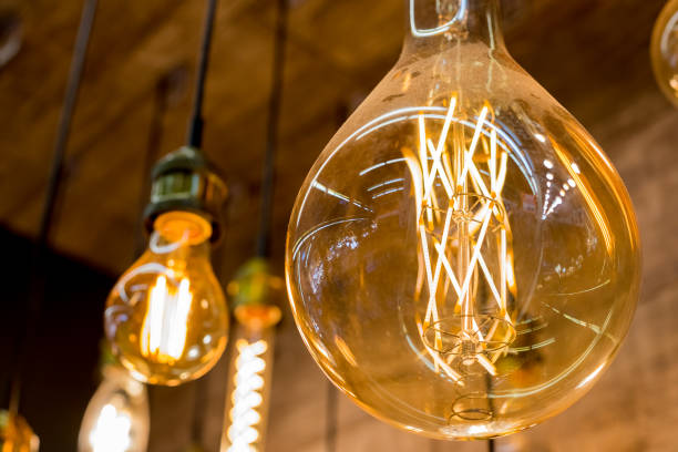 istock Beautiful retro luxury light lamp decor glowing.House interior of loft and rustic style. vintage light bulb hanging decor glowing in dark. Blend of history and modern.incandescent Edison type bulbs 1296563961