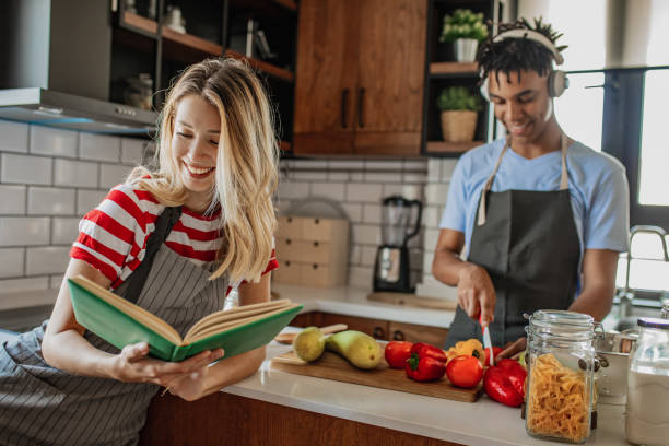 istock Young couple is looking for recipes in cookbook 1296564243