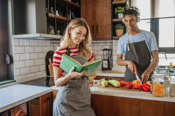 istock Young couple is looking for recipes in cookbook 1296564771