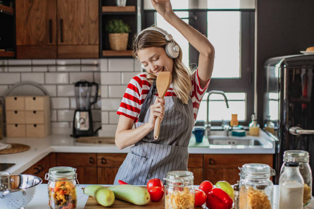 la joven se está divirtiendo en la cocina - women solitude enjoyment 20s fotografías e imágenes de stock