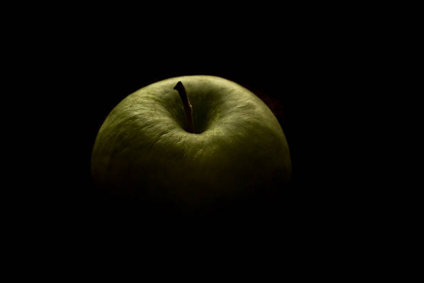 istock A green apple in the dark. 1296568201