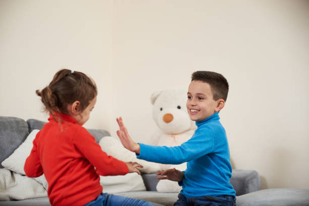 istock Happy boy and girl claping their hands while playing together. 1296568233