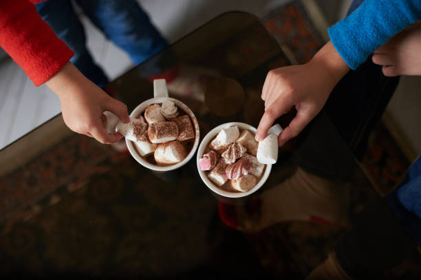 top view of two children hands holding cups with cocoa and marshmallows - babies and children close up horizontal looking at camera imagens e fotografias de stock