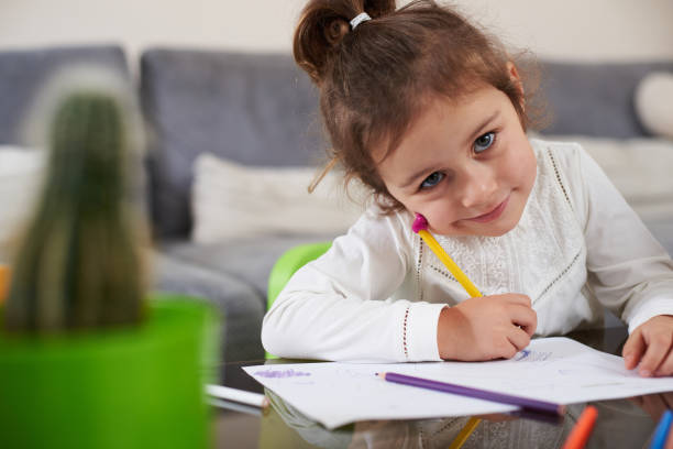istock A beautiful little girl learning to write and looking at camera 1296568694