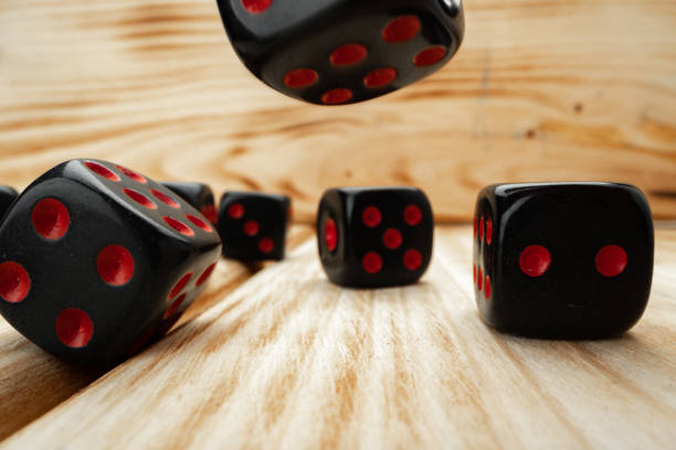 istock Macro of black tossed dice on wooden background 1296572812