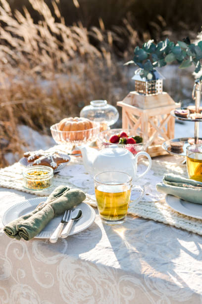istock Romantic Winter Tea Time Table Outdoors on sunny field 1296573412