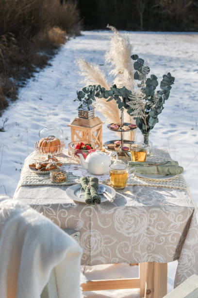 istock Romantic Winter Tea Time Table Outdoors on sunny field 1296573450