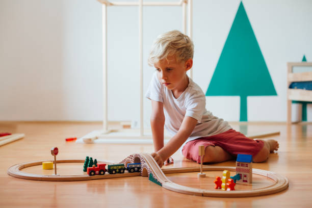 istock Little Boy Playing With Toy Railroad At Home 1296573788