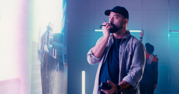 istock Man speaking on radio near LED display 1296581005