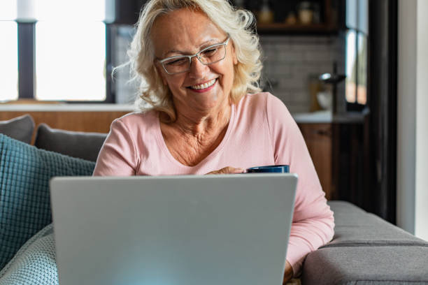 istock Senior woman relaxing at home and using laptop 1296585298
