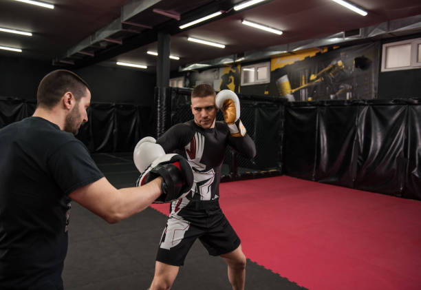 istock Male fighter practicing punches wearing boxing gloves 1296588480