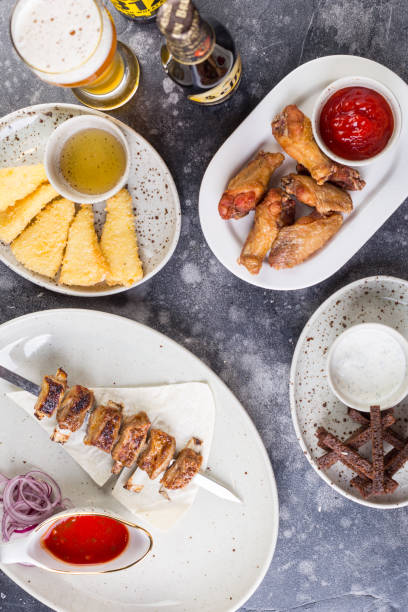 istock Gorgeous festive table with barbecue, chicken, cheese, beer and croutons 1296601947