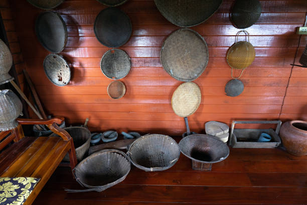 Traditional Thai kitchenware with handmade baskets on wooden wall