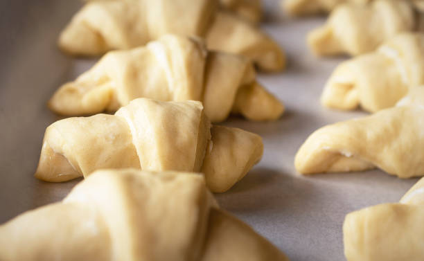 istock Rows of crescent rolls raise on parchment paper. 1296619000