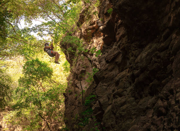 istock Hispanic woman on a zip line in Central America 1296626729