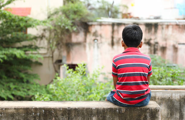 孤独に座っているインドの小さな男の子 - sadness child little boys loneliness ストックフォトと画像