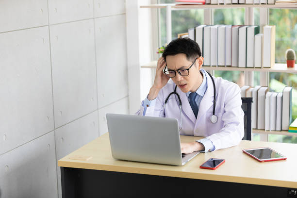 istock serious young asian doctor talking with co-worker through online video chat with computer in hospital 1296630433