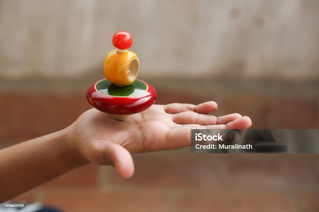 Boy holding Classic wooden spinning top Spinning Top Stock Photo