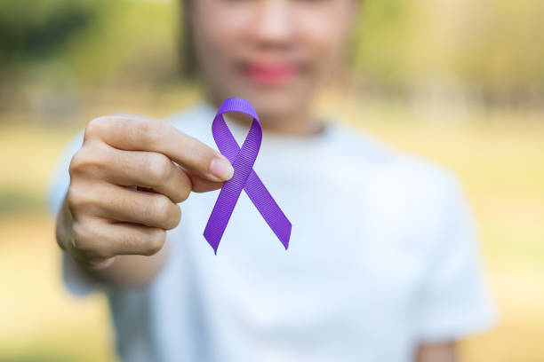 pankreas kanseri, dünya alzheimer, epilepsi, lupus ve aile içi şiddet gün farkındalık ay, kadın yaşayan insanları desteklemek için mor kurdele tutan. sağlık ve dünya kanser günü kavramı - alzheimer stok fotoğraflar ve resimler