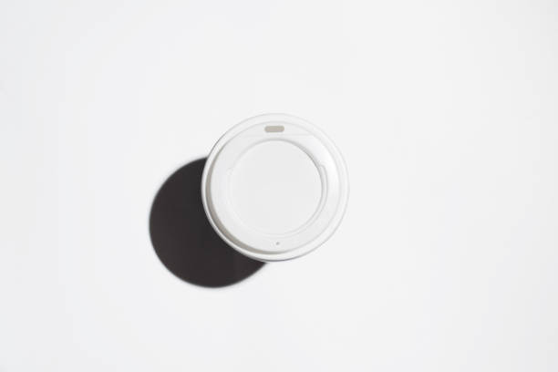 istock Disposable cup of coffee on a white background, top view. Minimalistic photo, selective focus 1296635866