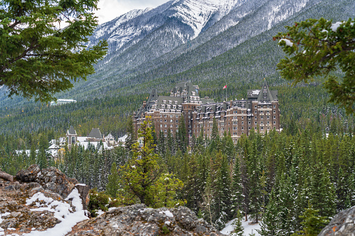 Fairmont Banff Springs in snowy autumn sunny day. View from Surprise Corner Viewpoint. Banff National Park, Canadian Rockies.
