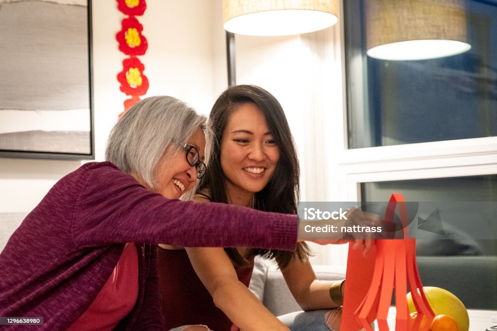 Preparing for Chinese New Year Celebrations Mother and adult daughter making lanterns for Chinese New Years. Traditional Chinese New Years at home. Modern Chinese culture. Chinese New Year Stock Photo