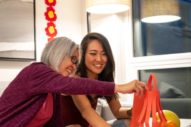 Preparing for Chinese New Year Celebrations Mother and adult daughter making lanterns for Chinese New Years. Traditional Chinese New Years at home. Modern Chinese culture. 60 64 years photos stock pictures, royalty-free photos & images