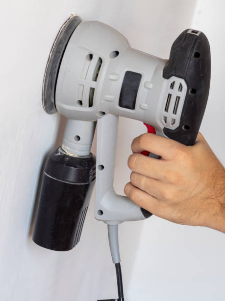 istock a Builder uses a sander to process a white concrete wall. Construction concert 1296639776