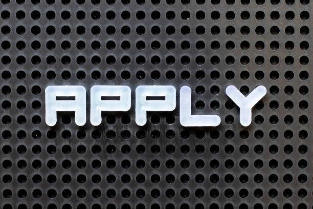 istock White color alphabet with word apply on black pegboard background 1296642254