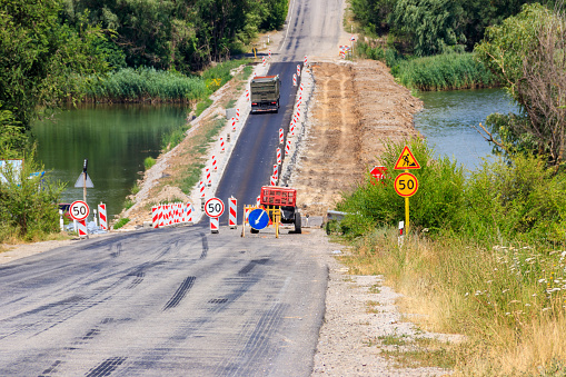 Road repair on the dam across the small river