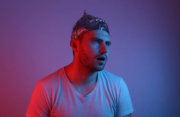 istock Pensive bearded Man in a foil hat in red-blue neon light. 1296645800