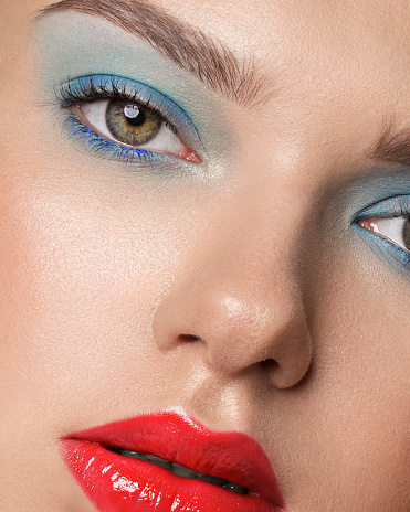 blue eyeshadow red lipstick close up woman's face