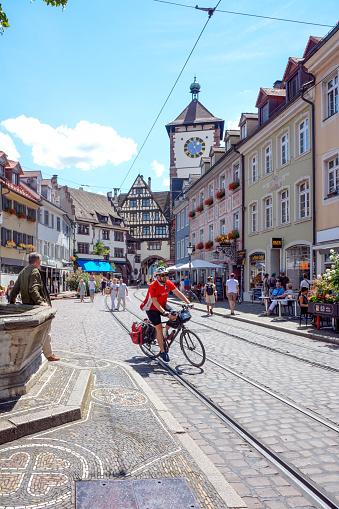Freiburg im Breisgau, July 25, 2020, Baden-Württemberg, Germany: Oberlinden with a view of the Schwabentor, one of the city's preserved city gates. In addition to pedestrians and the tram, there are cyclists here.