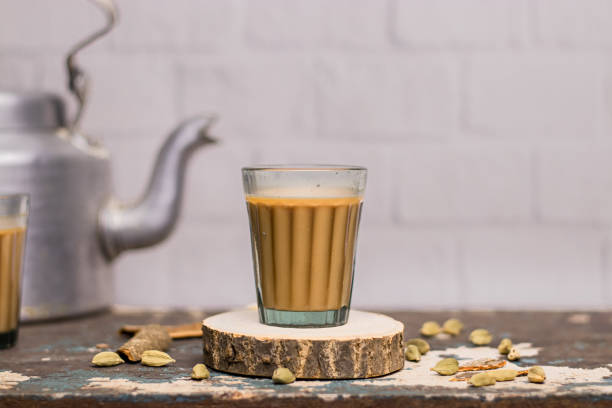 Indian chai in glass cups with metal kettle and other masalas to make the tea. Indian chai in glass cups with metal kettle and other masalas to make the tea. cardamom stock pictures, royalty-free photos & images