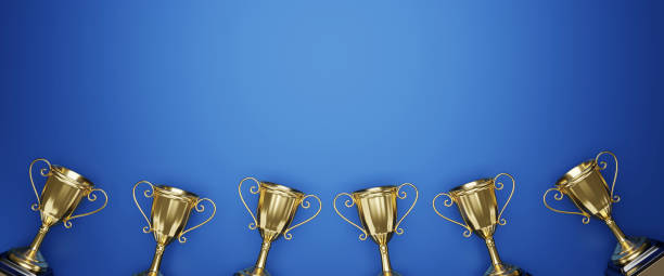 istock Fat lay Golden trophy cup on blue background. copy space for text. 3d rendering. 1296652510