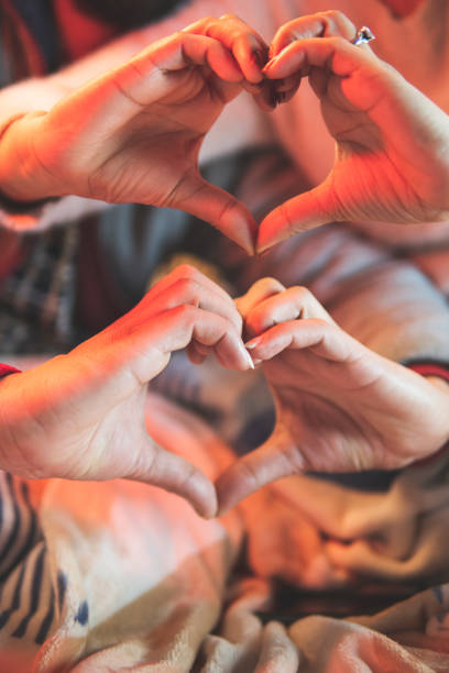 istock Couple in love making heart shape together through hands. 1296653481