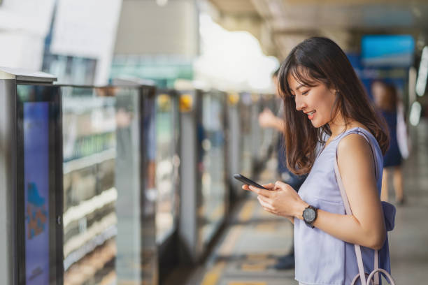 istock Young Asian woman passenger using social network via smart mobile phone in subway train when traveling in big city,japanese,chinese,Korean lifestyle and daily life, commuter and transportation concept 1296656145