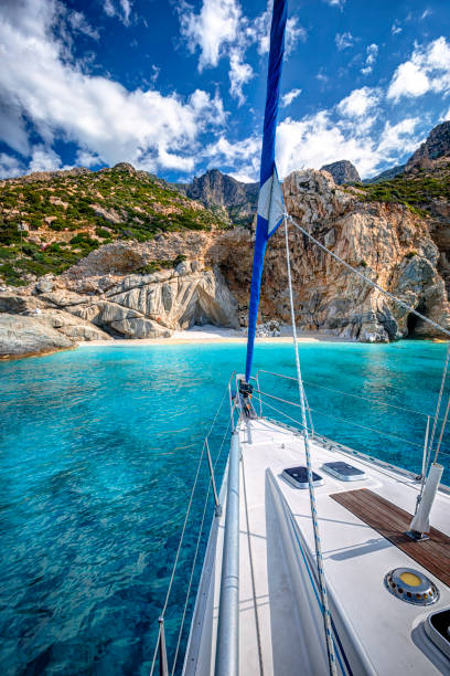 Sailing yacht relaxing at the beach of Seychelles, with transparent turquoise waters, in Ikaria island, Greece Sailing yacht relaxing at the beach of Seychelles, with transparent turquoise waters, in Ikaria island, Greece ikaria island stock pictures, royalty-free photos & images