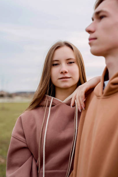 istock Young couple standing outdoors in cloudy day 1296658176