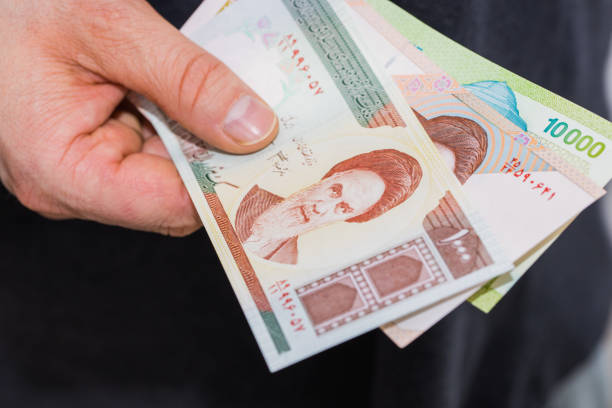 istock Iranian bills, Riyal, Assorted values, Money spread out and held in the hand 1296658220