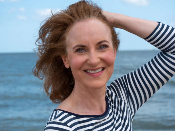 istock Smiling mature woman at beach. 1296659065