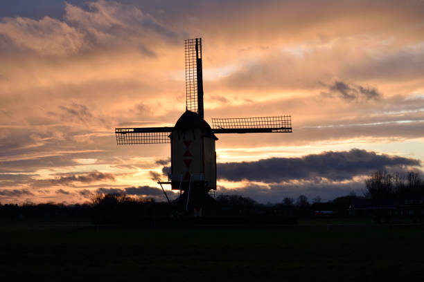 istock A typical windmill located in the Netherlands silhouetted by the sun setting in the background 1296659444
