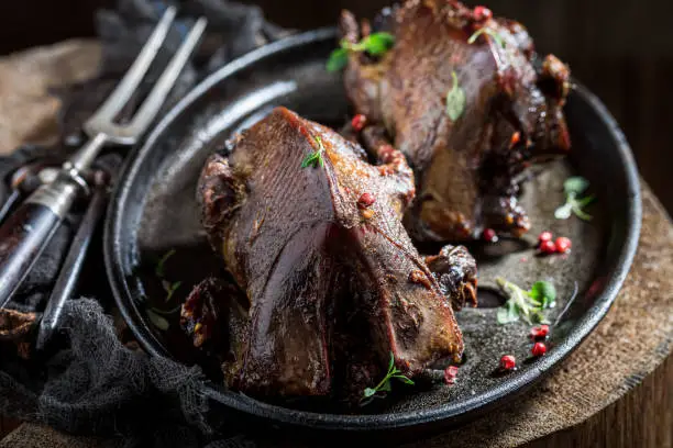 Photo of Closeup of two roasted pigeons with spices and pepper