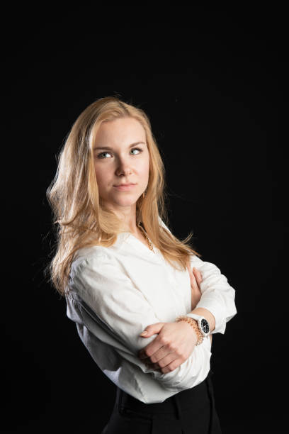 istock stands on a black background in a white blouse. Cheerful, comparison concept, in the studio, business woman, blonde 1296660589