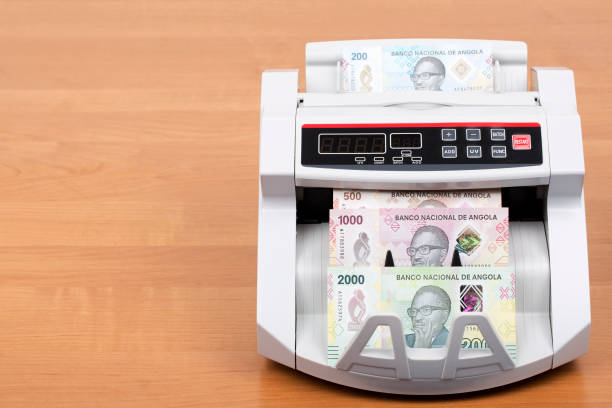 Angolan money a new series of banknotes in the counting machine Angolan money - Kwanza a new series of banknotes in the counting machine angolan kwanza photos stock pictures, royalty-free photos & images