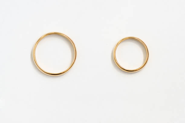 istock Gold rings top view over white paper. 1296662466