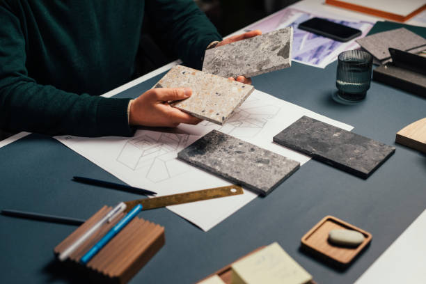 istock Hands of an architect Working at His Studio: Choosing Stone Flooring Samples, a Close Up 1296662509