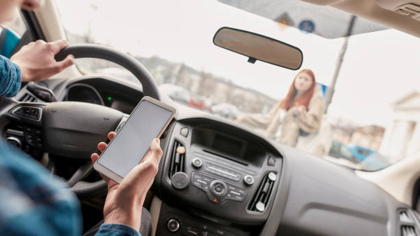 보행자를 통해 실행하는 동안 자신의 휴대 전화를 사용하여 산만 젊은 남성 드라이버. 기술 및 운송 개념 - driving text messaging accident danger 뉴스 사진 이미지