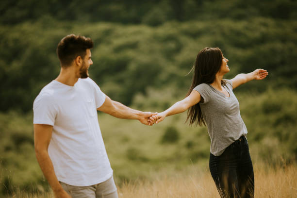 istock Happy young couple in love walking through grass field 1296664814