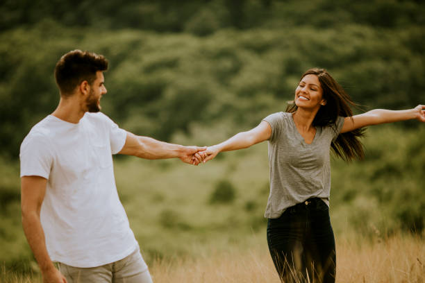 istock Happy young couple in love walking through grass field 1296664821